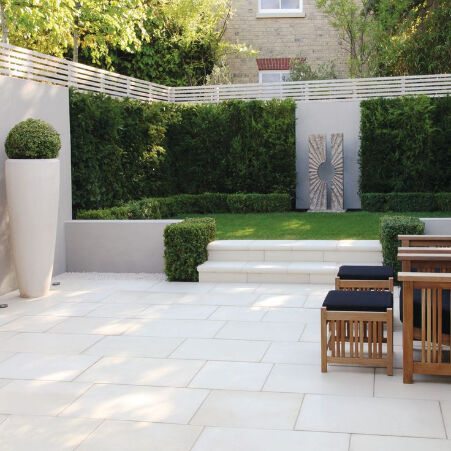 Light porcelain paving laid across a landscaped garden patio