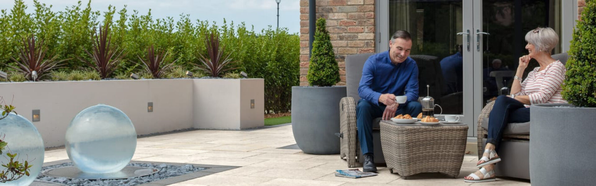 Contemporary outdoor porcelain patio in a landscaped UK garden at golden hour